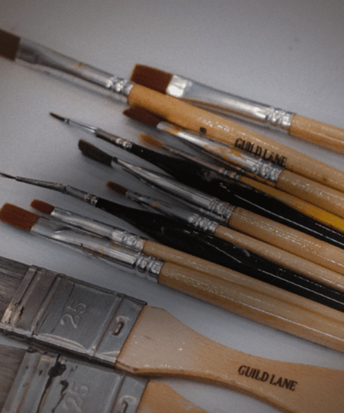 Set of paintbrushes with wooden handles and metal ferrules on a light background