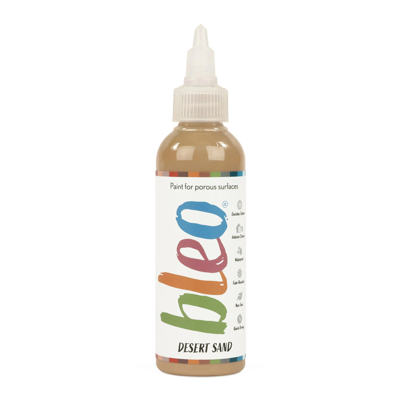 A bottle containing coloured gel paint, on a white background of bleo desert sand