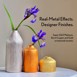 
                      
                        Three textured ceramic vases in platinum, burnt copper, and gold with purple flowers on a neutral background.
                      
                    
