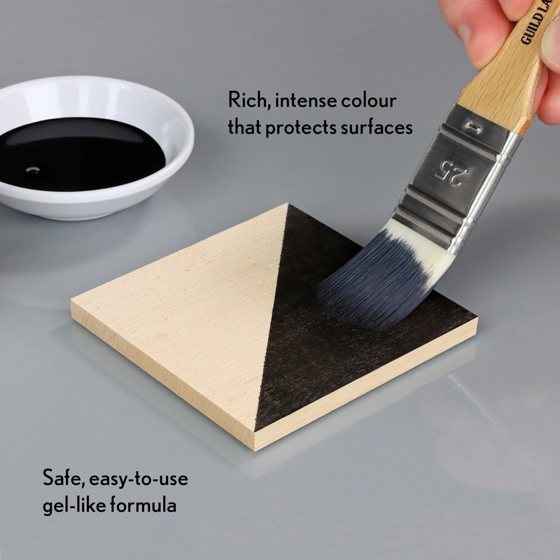 Brush applying black gel-like substance to a triangular wooden block with text about product features.