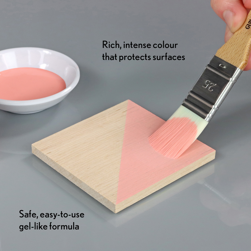 Person applying pink gel-like substance to a wooden block with a brush, text highlighting features.