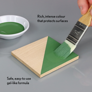 
                      
                        Green paint being applied to a wooden triangle with text about the paint's properties.
                      
                    