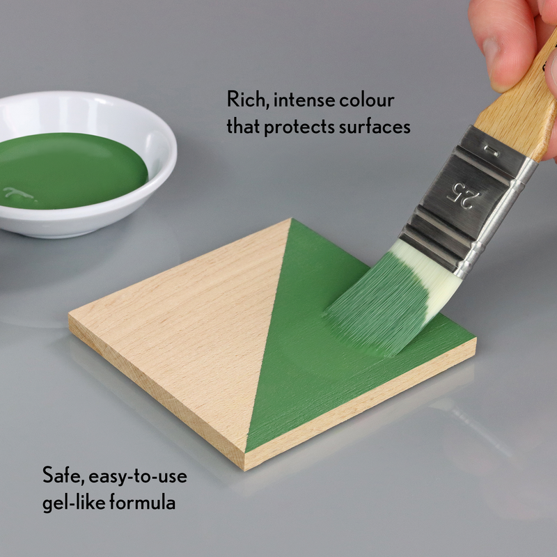 Green paint being applied to a wooden triangle with text about the paint's properties.