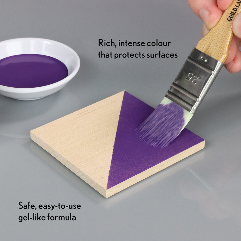 Purple paint being applied to a wooden triangle with text about the paint's properties.