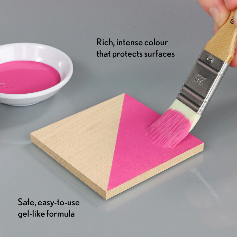Pink paint being applied to a wooden triangle with text about the paint's properties.