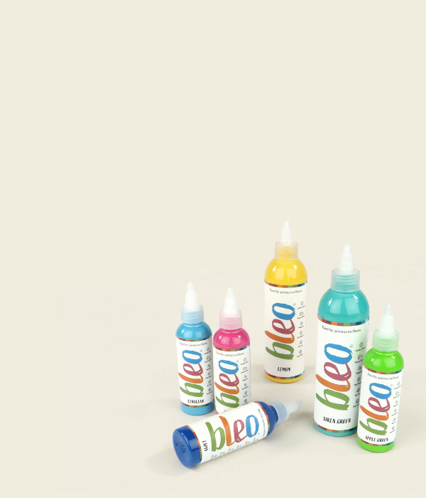 Bleo porous surface paint for fabric and wood, bottles of different Bleo colours on a cream surface