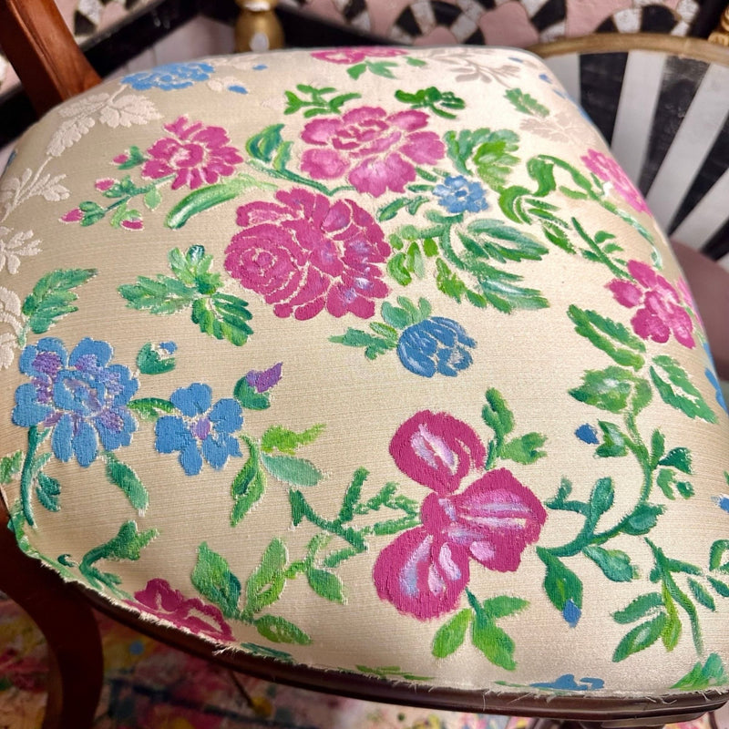 Floral-patterned cushion on a chair with a colourful design.