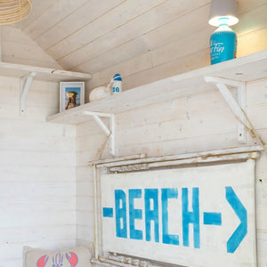 
                      
                        White washed wood in a beach hut with blue accents
                      
                    