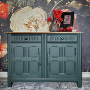 
                      
                        British Racing Car Green Jubilee Painted Green cabinet with decorative items against a floral wallpapered wall
                      
                    