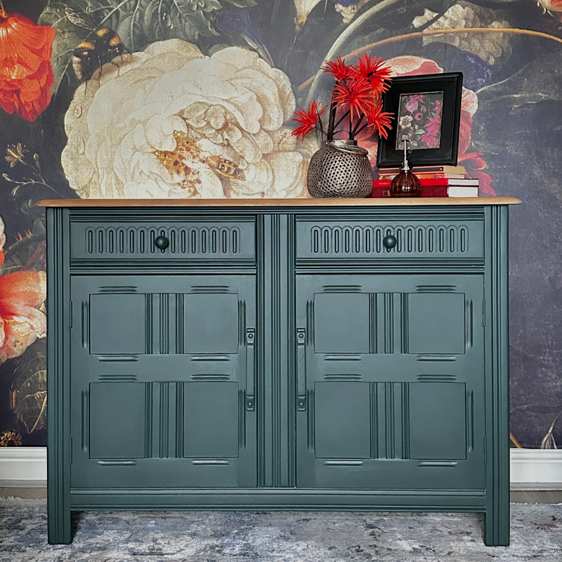 British Racing Car Green Jubilee Painted Green cabinet with decorative items against a floral wallpapered wall