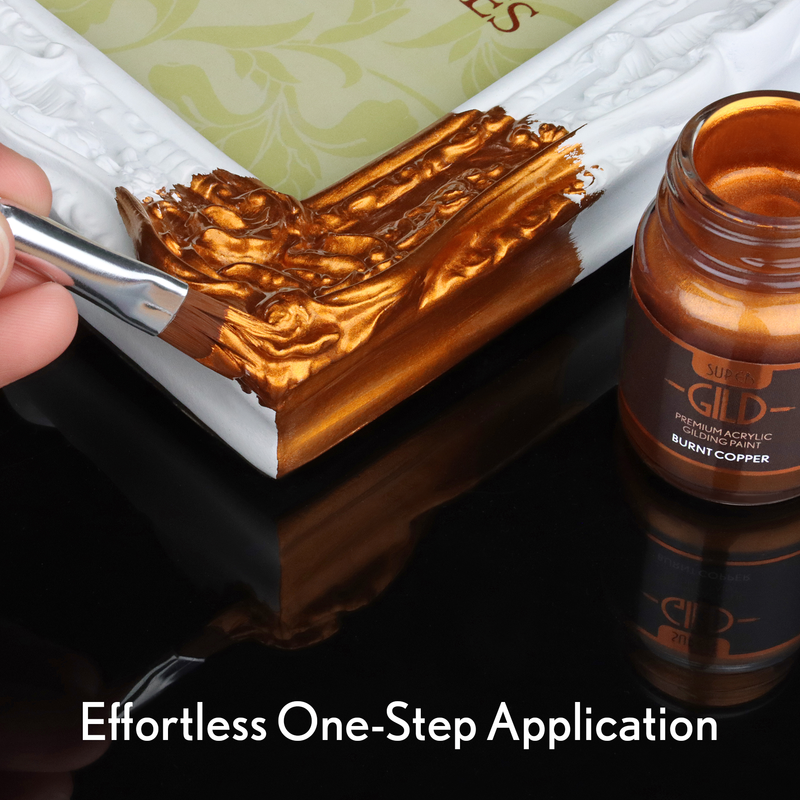 Copper paint being applied with a brush to a surface, next to a jar of gold paint labelled 'Gild'.