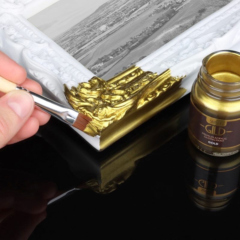 Person painting gold metallic paint onto a resin frame
