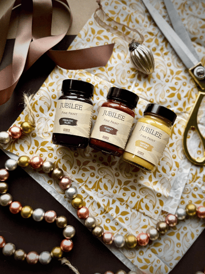 Three bottles of Jubilee on a decorative surface with ribbons and scissors.