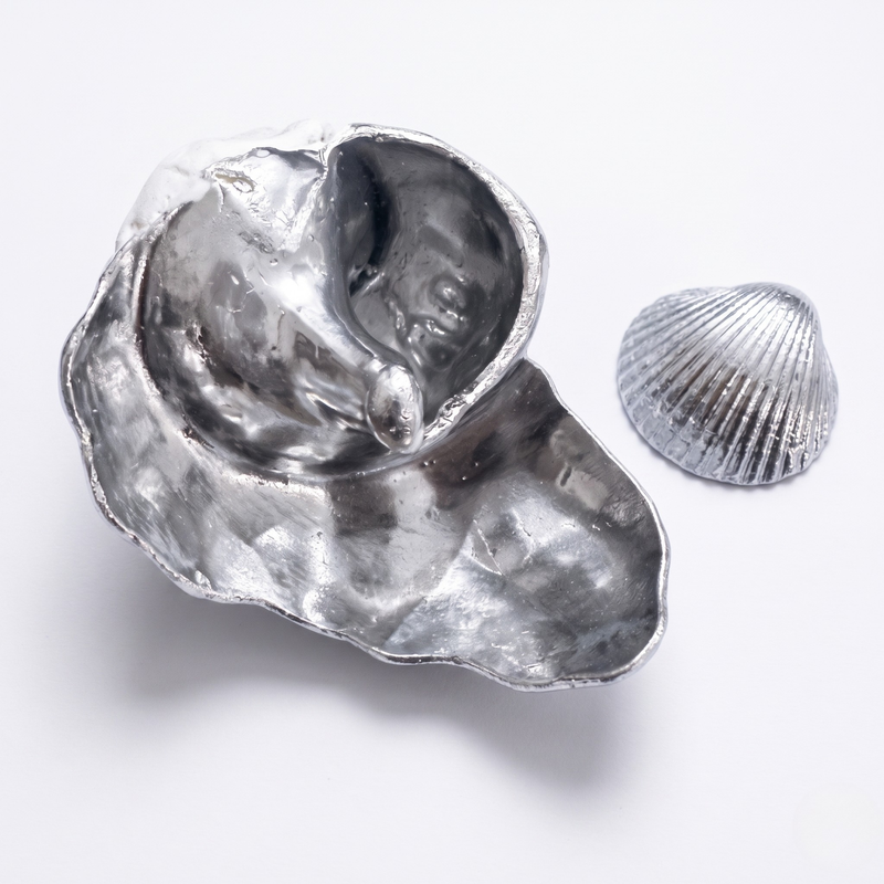 Silver shell painted in metallic chrome mirror silver with a smaller silver shell on a white background