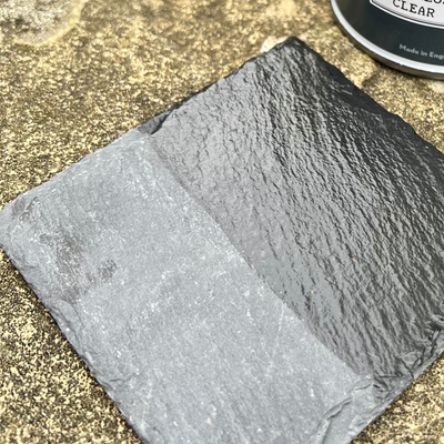 Piece of slate painted with a can of clear sealant in the background.