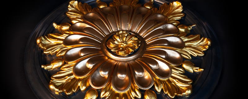 Decorative gold ceiling rose on a dark background
