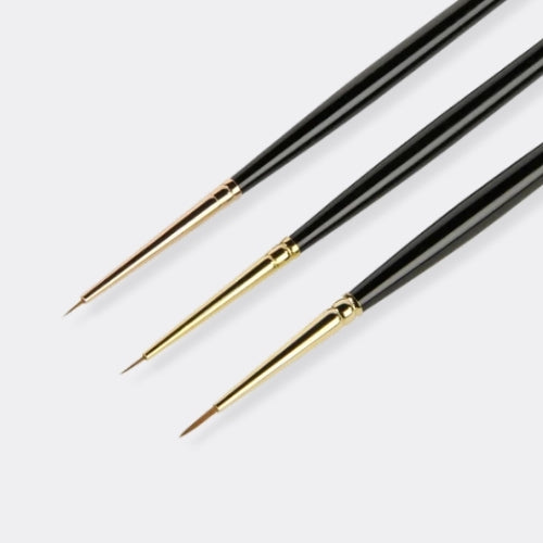 Three fine paint brushes with black handles and gold ferrules, arranged diagonally on a light grey background.