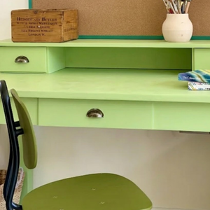 
                      
                        Eau de nil painted green desk with supplies on
                      
                    