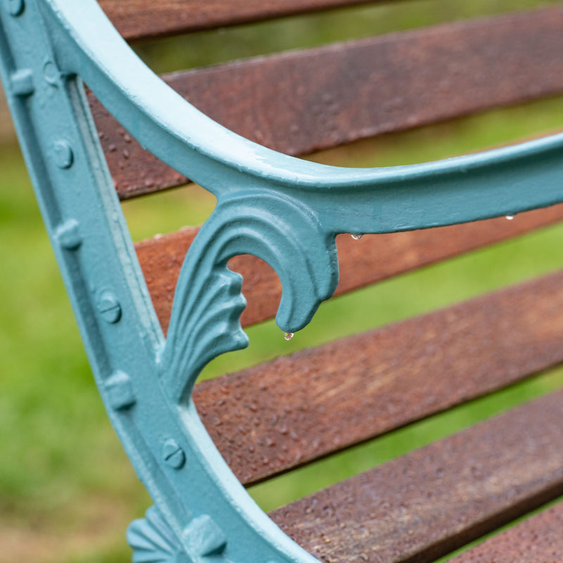 Close up of water on painted blue metal outdoor bench