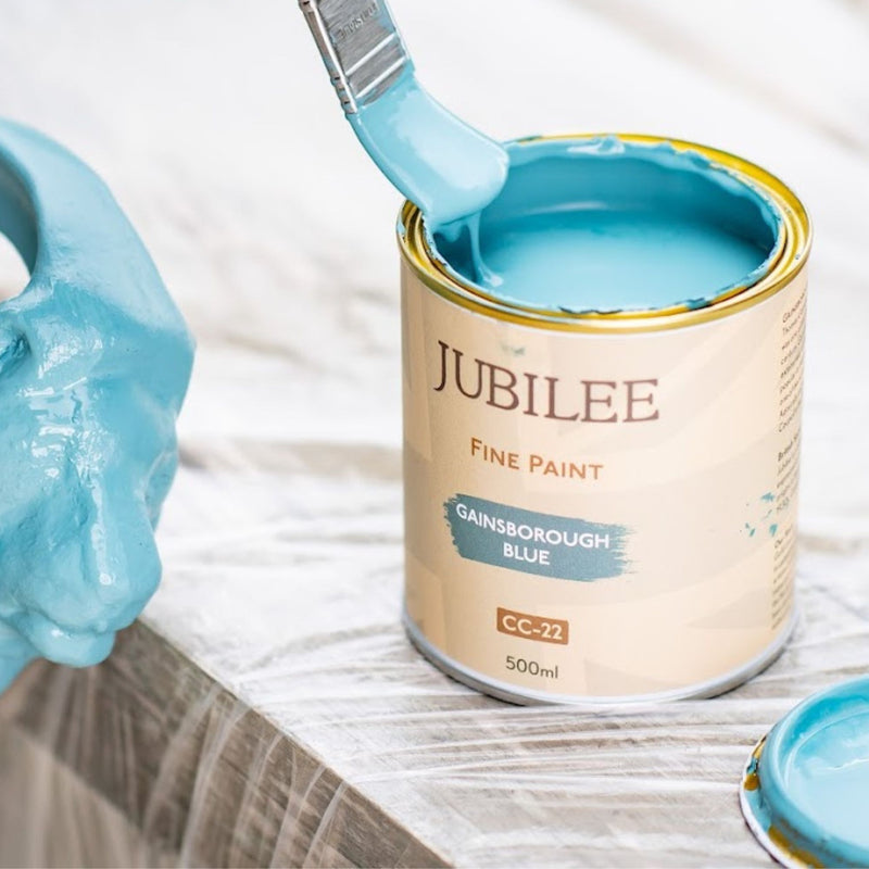 Tin of blue paint being brushed