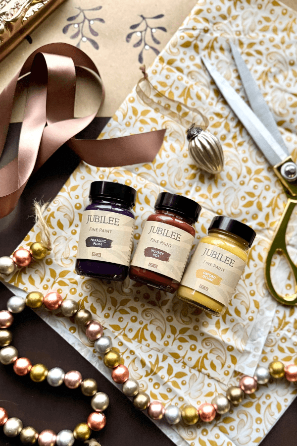 Three Jubilee products on a decorative surface with ribbons and scissors.