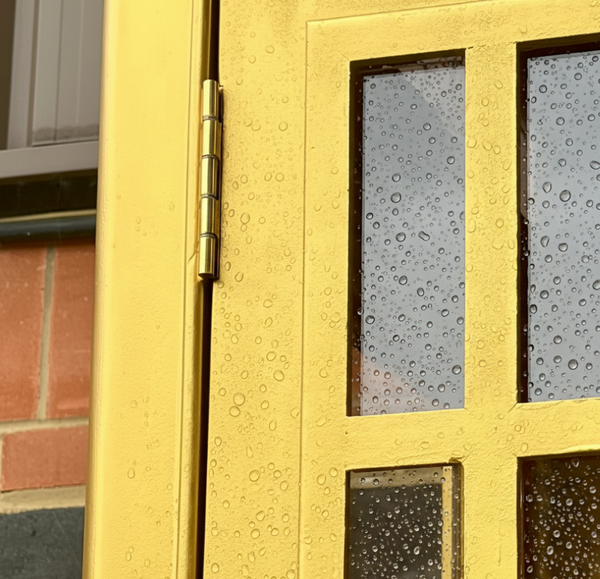 Gold door with glass panels and water droplets on a brick wall background