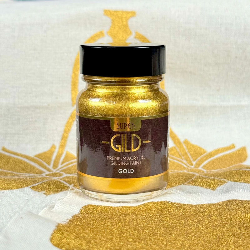 Jar of Super Gild gold acrylic gilding paint on a white background with gold leaf.