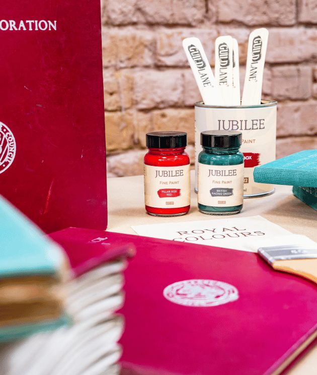 Jubilee paint products on a table with a brick wall background