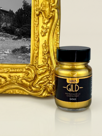 Jar of Super Gild gilding paint next to a gold decorative frame on a white background