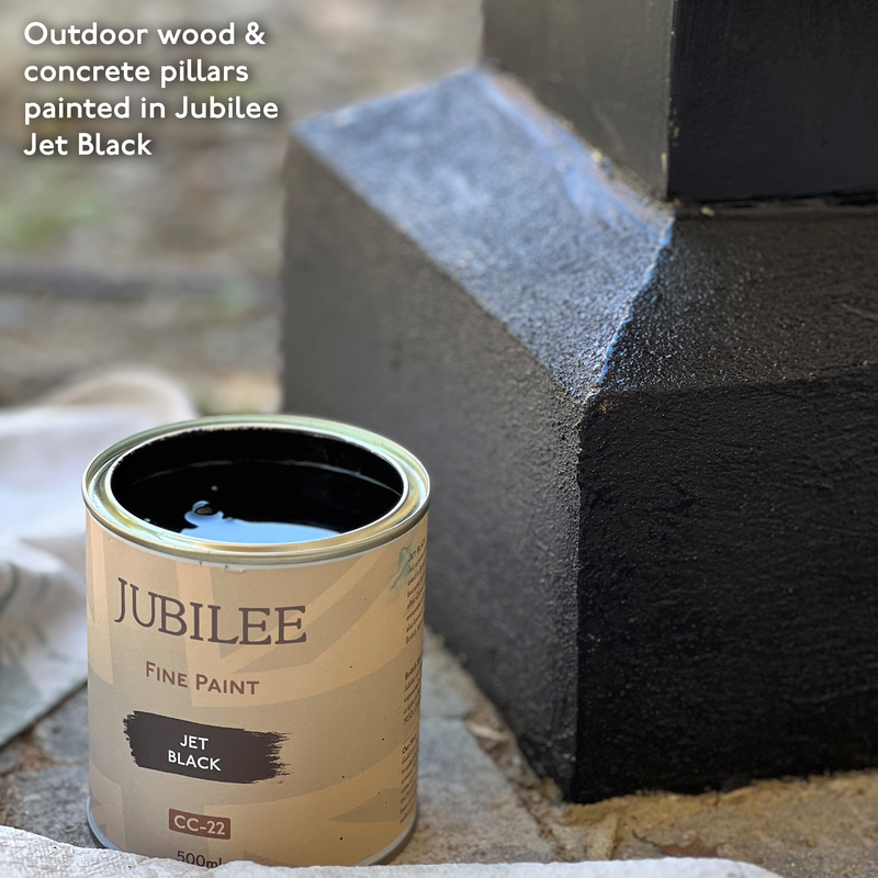 Jubilee Fine Paint can next to a black-painted concrete pillar with text about painting wood and concrete in Jubilee Jet Black.