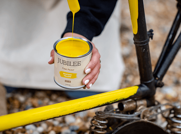Bike being painted outdoors using Jubilee bunting yellow durable paint