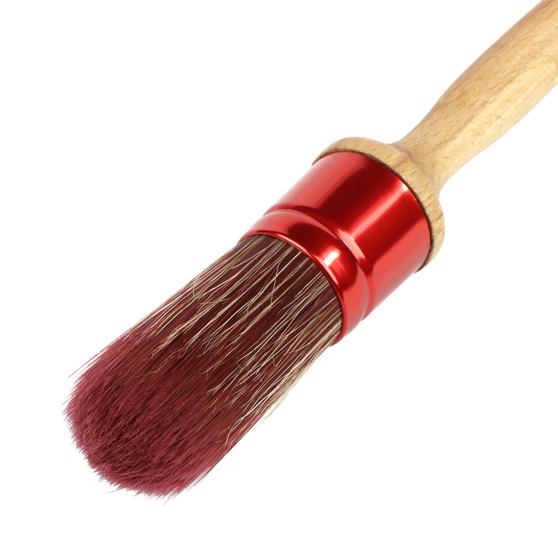 Brush with red ferrule and wooden handle on a white background