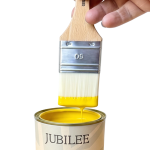 
                      
                        Can of Jubilee fine paint with a brush dipping into yellow paint
                      
                    