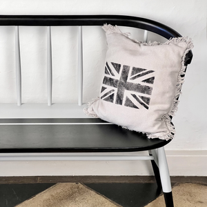 
                      
                        Decorative pillow with a Union Jack design on a black and white bench.
                      
                    
