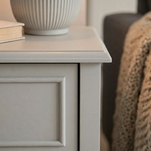 
                      
                        Close up corner of a light grey cabinet next to a blanket and a sofa
                      
                    