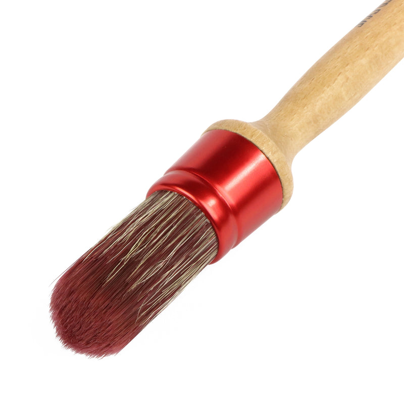 Brush with red ferrule and wooden handle on a white background