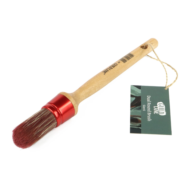 Dual ended brush with red bristle end and wooden handle on a white background