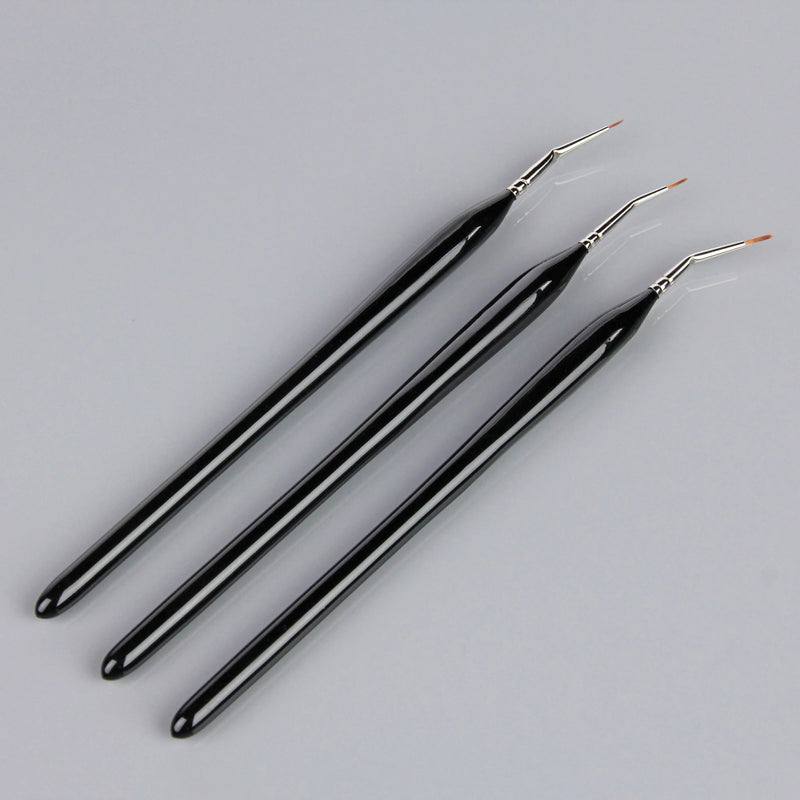 Three black art brushes on a grey background