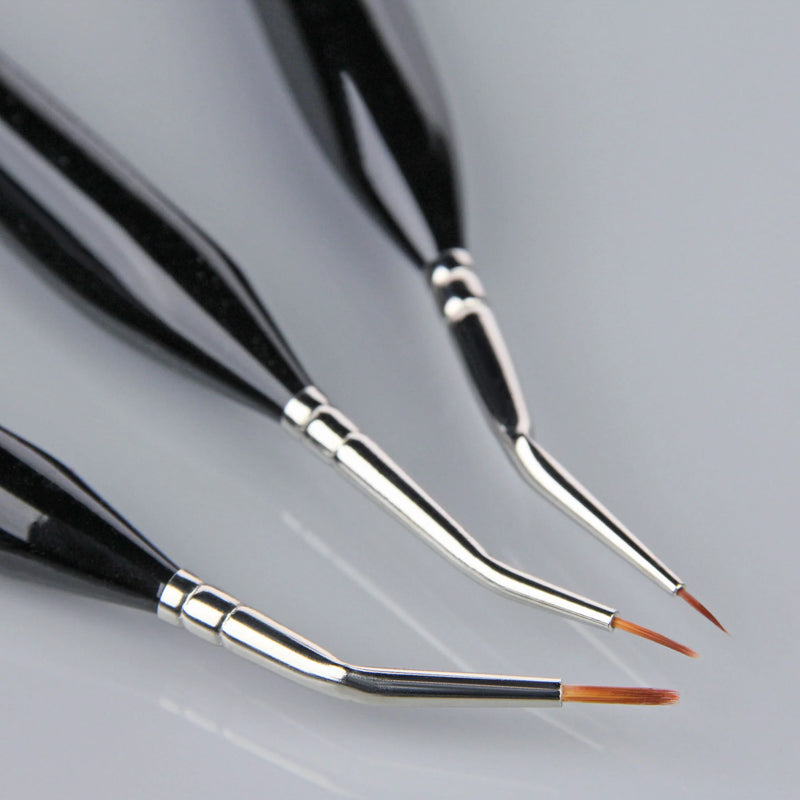 Set of three paintbrushes with black handles and silver ferrules on a gray background