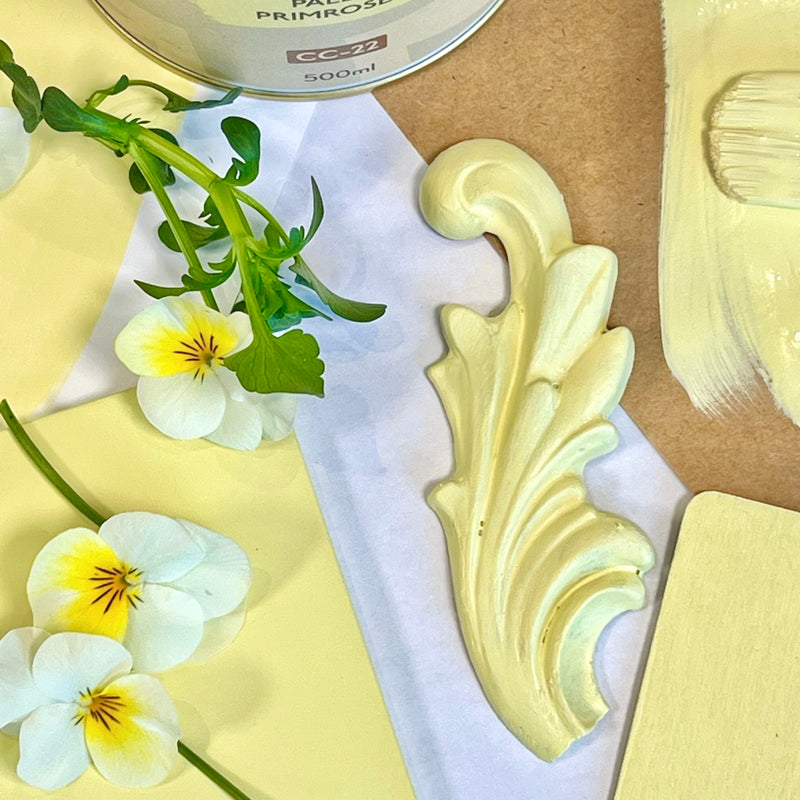 Decorative painted yellow trim with floral elements on a light background