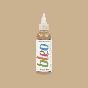 Bottle of 'bleo' desert sand paint on a beige background