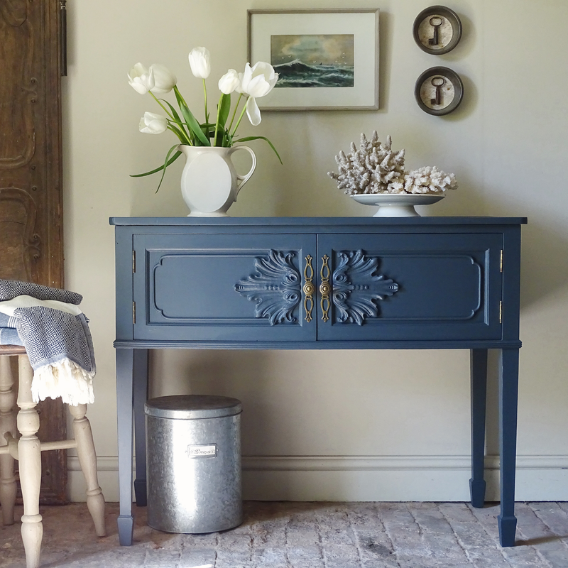 Blue console table with decorative elements in a room setting