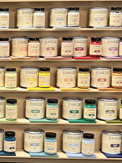 Shelves displaying various jars of Jubilee paint in different colors.