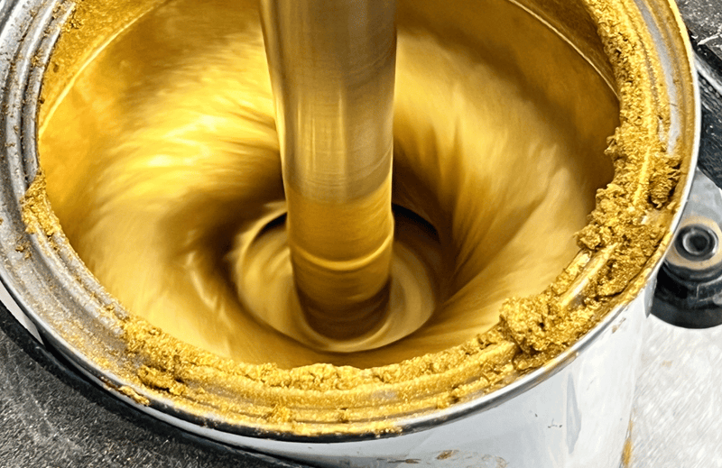 Gold paint being poured into a container
