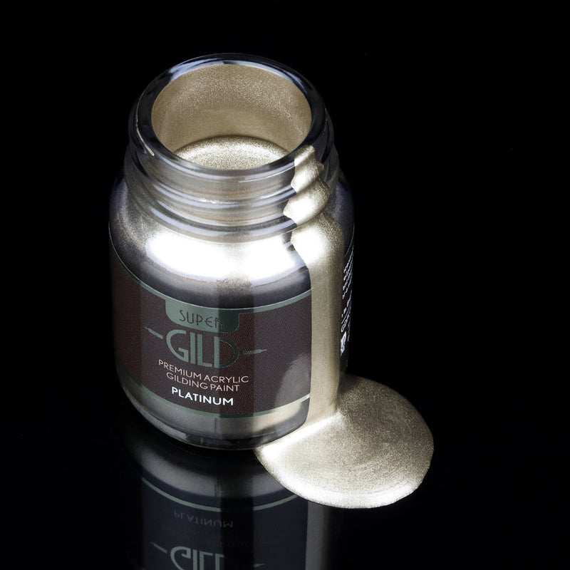 Super GILD Platinum acrylic gilding paint in a jar with metallic paint pooling onto a black background