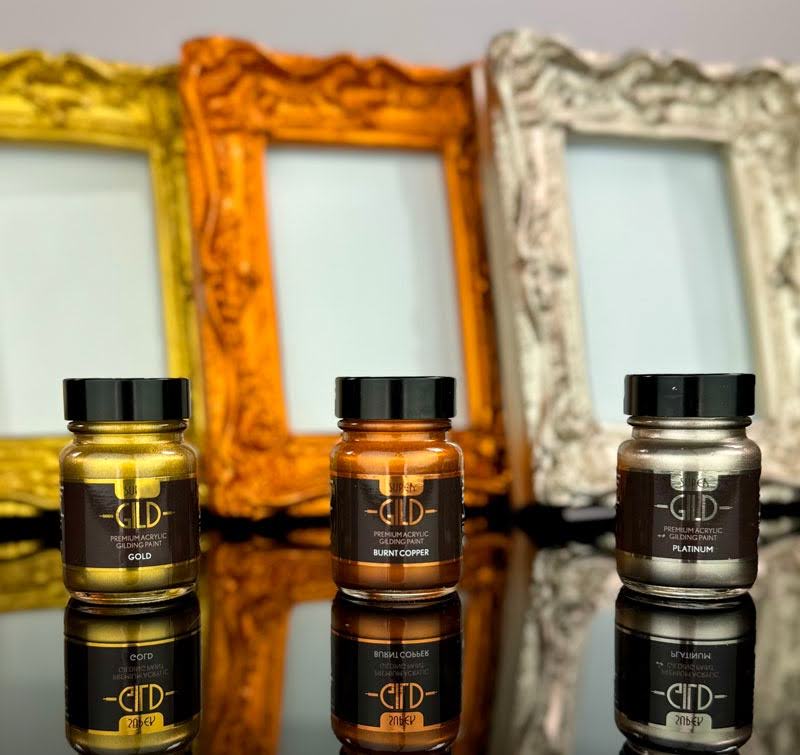 Three bottles of Super GILD metallic paint on decorative frames in the background