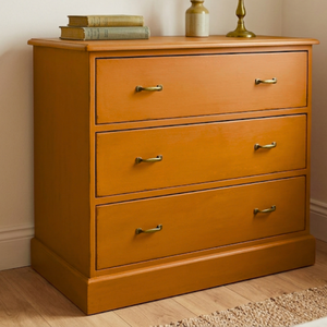 
                      
                        Refined orange painted chest of drawers cabinet with old objects on top
                      
                    