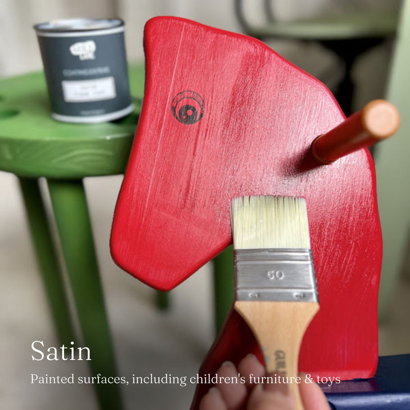Red painted horse rocking chair with a brush on a blurred background