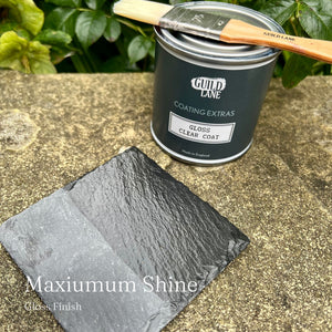 
                      
                        Can of Guild Lane paint with a brush and sample on a stone surface
                      
                    