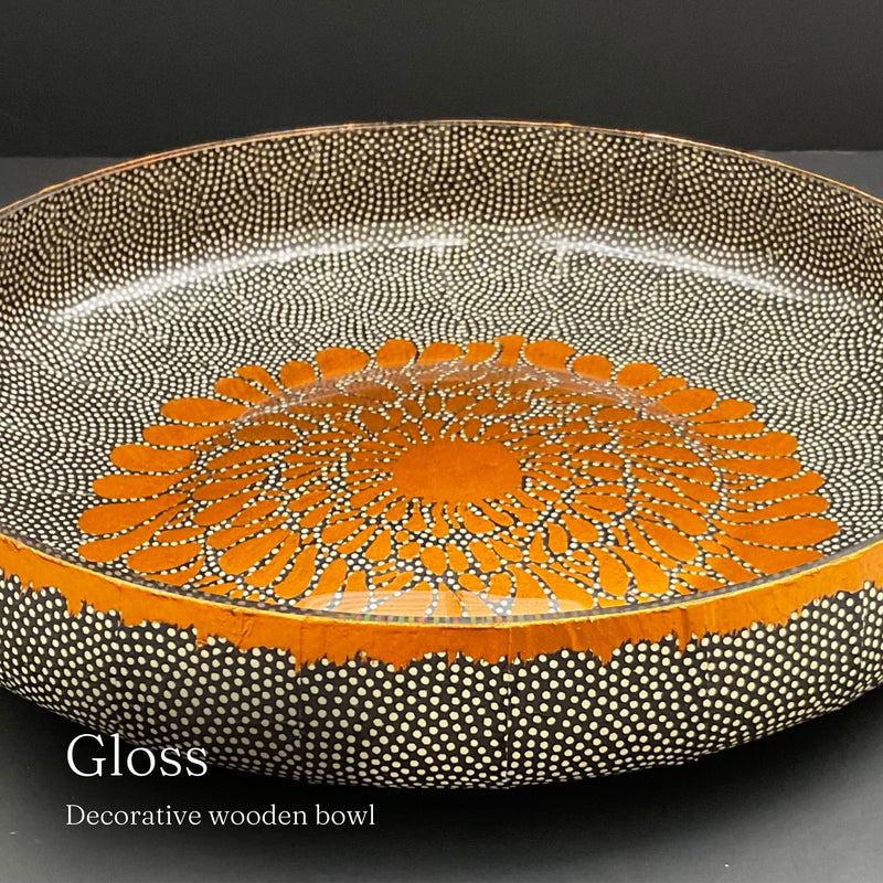 Decorative ceramic bowl with orange and black pattern on a dark background